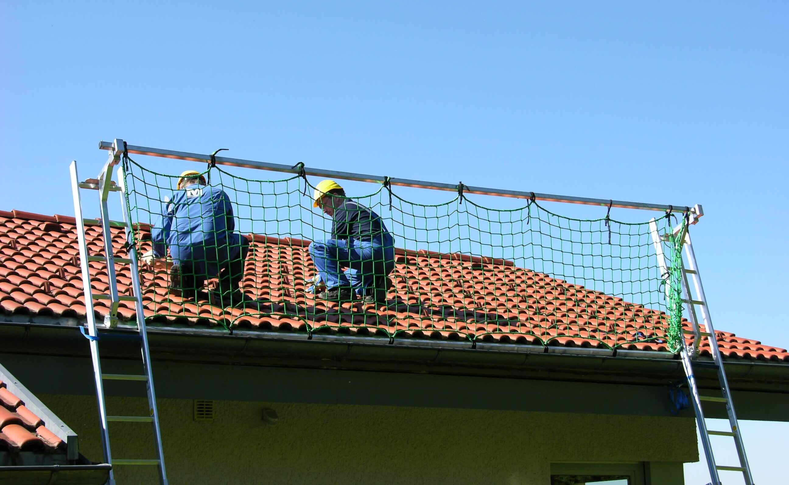 Männer auf einem Dach mit Dachschutzwand